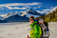 Jenn on the shore of the Spray Lakes Reservoir with Mount Morrison and Mount Turner beyond.