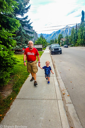 Uncle Bruce and James walking along the sideway in Canmore.