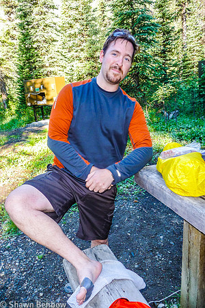 Adam showing off his duct-taped feet at breakfast at Helmet Falls Campground.